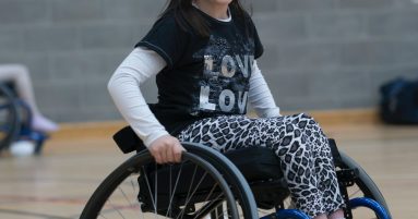 girl in black and white long sleeve shirt sitting on black wheelchair