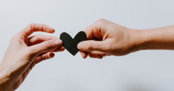 two person holding papercut heart